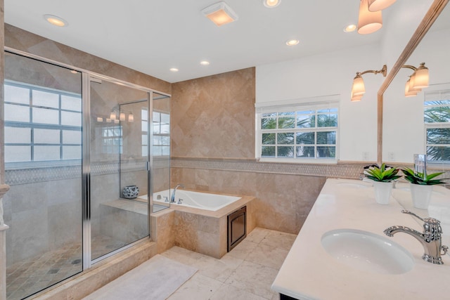 bathroom featuring tile walls, shower with separate bathtub, and vanity