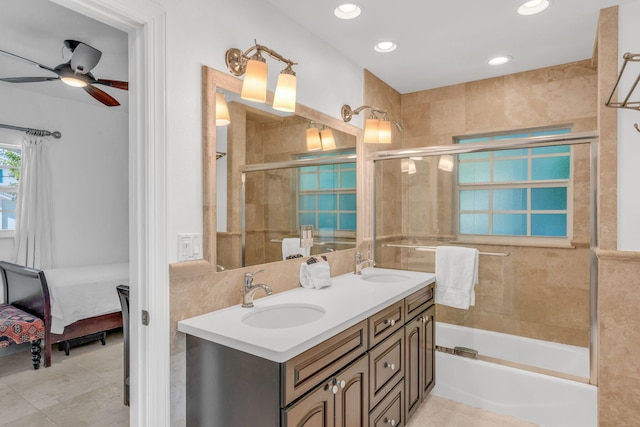 bathroom featuring tile walls, vanity, combined bath / shower with glass door, ceiling fan, and tile patterned floors