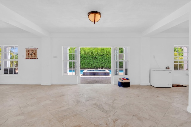 unfurnished room featuring beamed ceiling