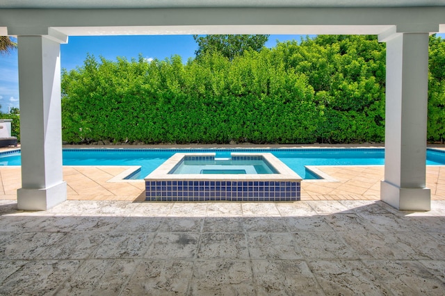 view of swimming pool with a patio and an in ground hot tub