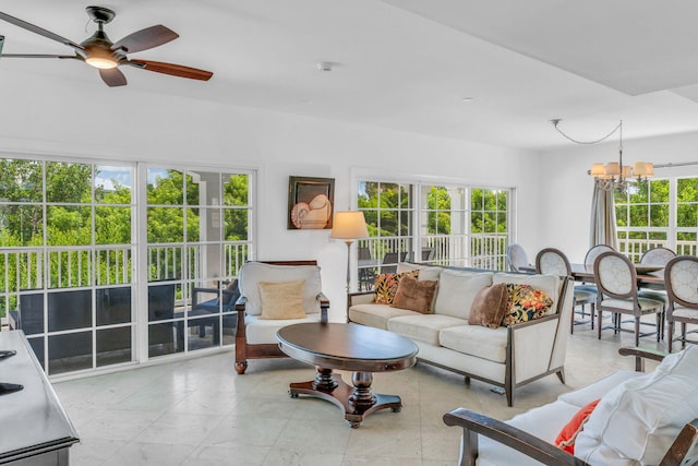 living room with ceiling fan with notable chandelier