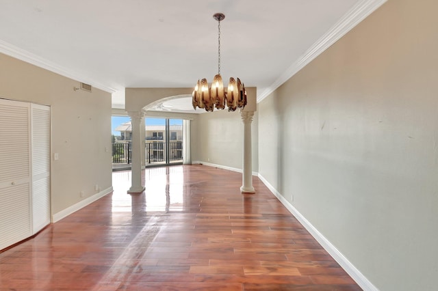 unfurnished dining area with dark hardwood / wood-style floors, ornate columns, ornamental molding, and an inviting chandelier