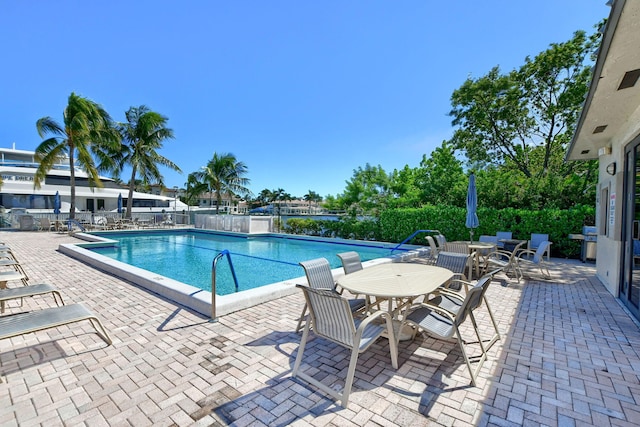 view of swimming pool featuring a grill and a patio