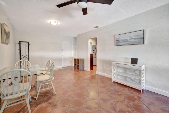 dining space featuring a textured ceiling and ceiling fan