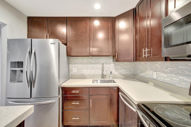 kitchen featuring decorative backsplash, sink, and stainless steel appliances