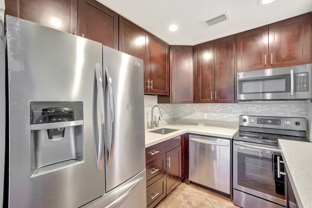 kitchen with appliances with stainless steel finishes, sink, and tasteful backsplash