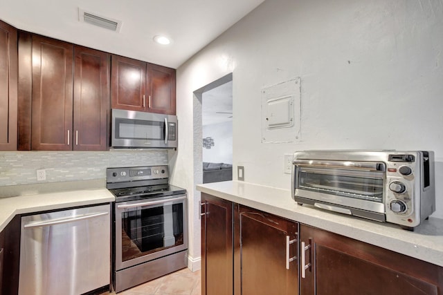 kitchen with stainless steel appliances, backsplash, and light tile patterned floors