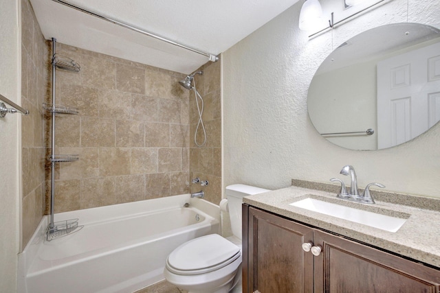 full bathroom featuring vanity, tiled shower / bath, and toilet