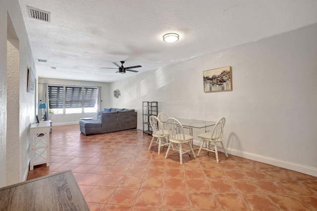 dining space featuring ceiling fan and a textured ceiling