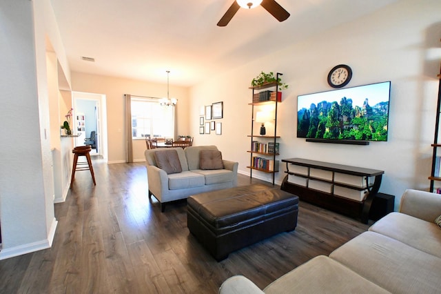 living room with ceiling fan with notable chandelier and dark hardwood / wood-style floors