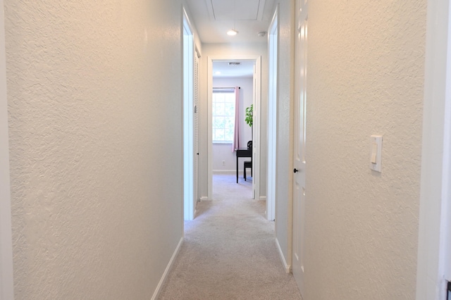 hall featuring light colored carpet