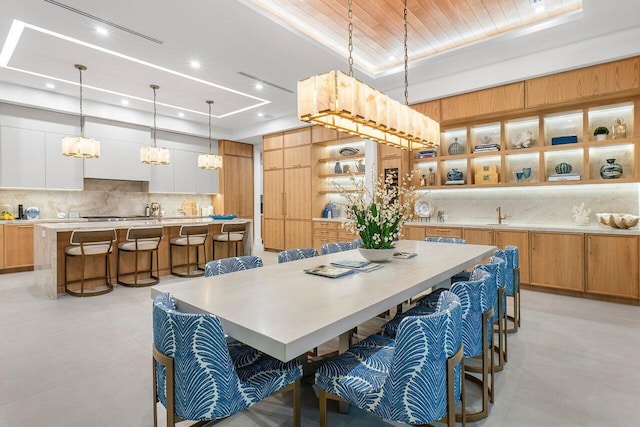 kitchen featuring light stone countertops, backsplash, light tile patterned floors, and sink