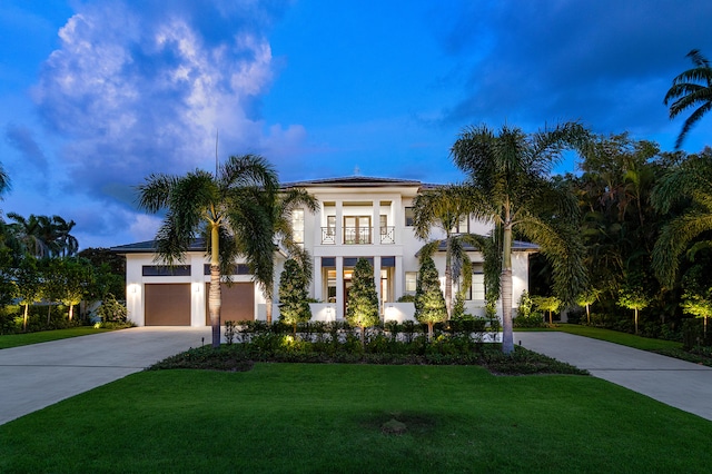 mediterranean / spanish-style home featuring a yard and a garage