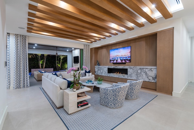 living room featuring beam ceiling and a high end fireplace