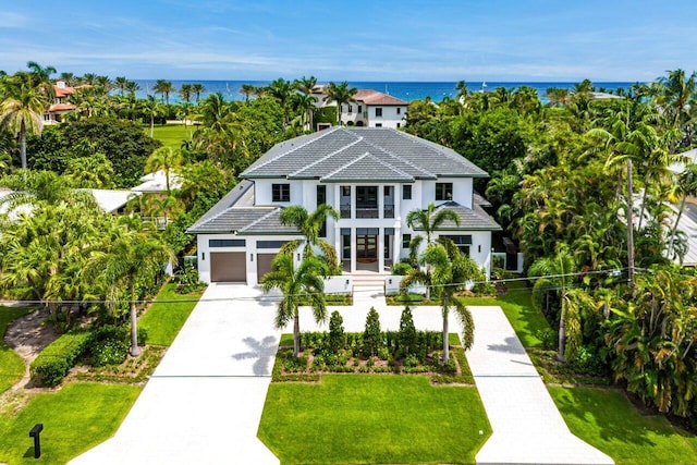 view of front of house featuring a garage, a water view, and a front lawn