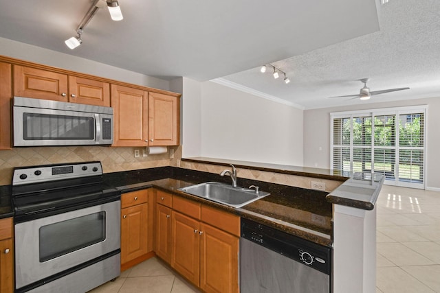 kitchen featuring kitchen peninsula, a textured ceiling, stainless steel appliances, sink, and light tile patterned flooring