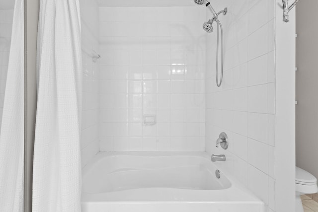 bathroom with tile patterned floors, shower / bath combination with curtain, and toilet