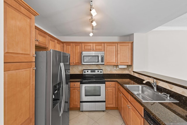 kitchen featuring sink, stainless steel appliances, dark stone countertops, light tile patterned floors, and ornamental molding