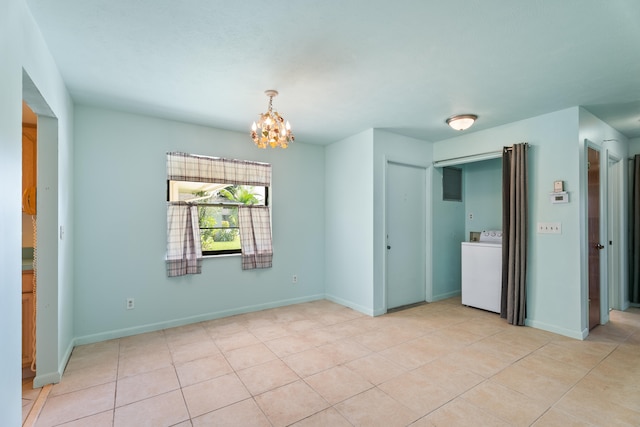 tiled spare room with a chandelier and washer / dryer