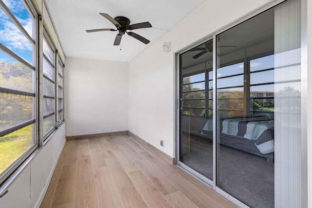 unfurnished sunroom featuring ceiling fan