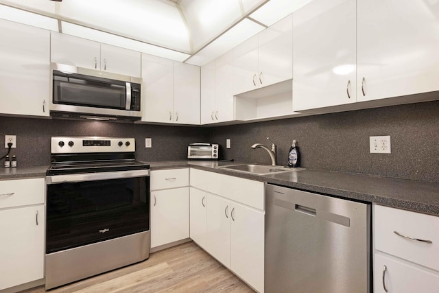 kitchen featuring white cabinets, appliances with stainless steel finishes, sink, and tasteful backsplash