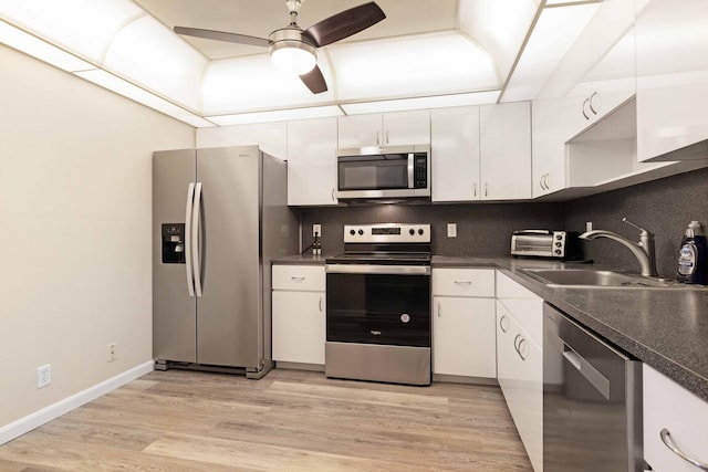 kitchen featuring appliances with stainless steel finishes, decorative backsplash, white cabinetry, and ceiling fan