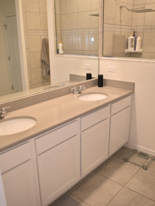 bathroom featuring a tile shower, tile patterned floors, and vanity