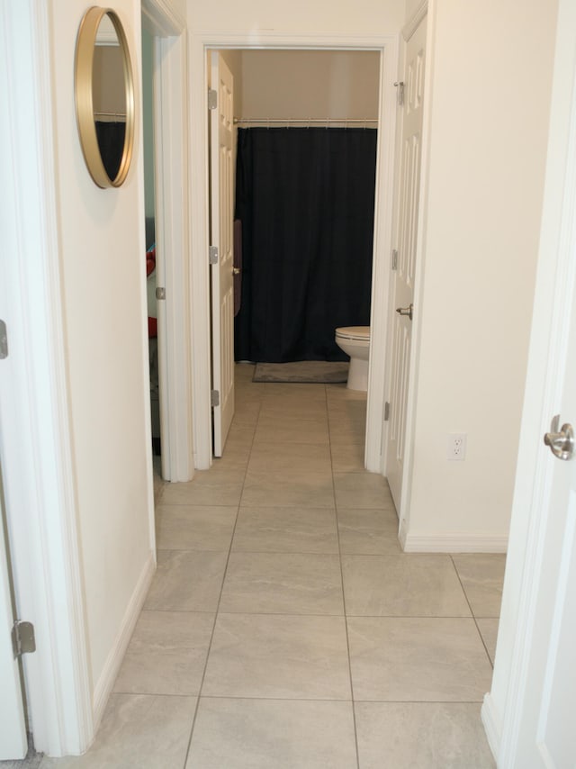 hall featuring light tile patterned floors