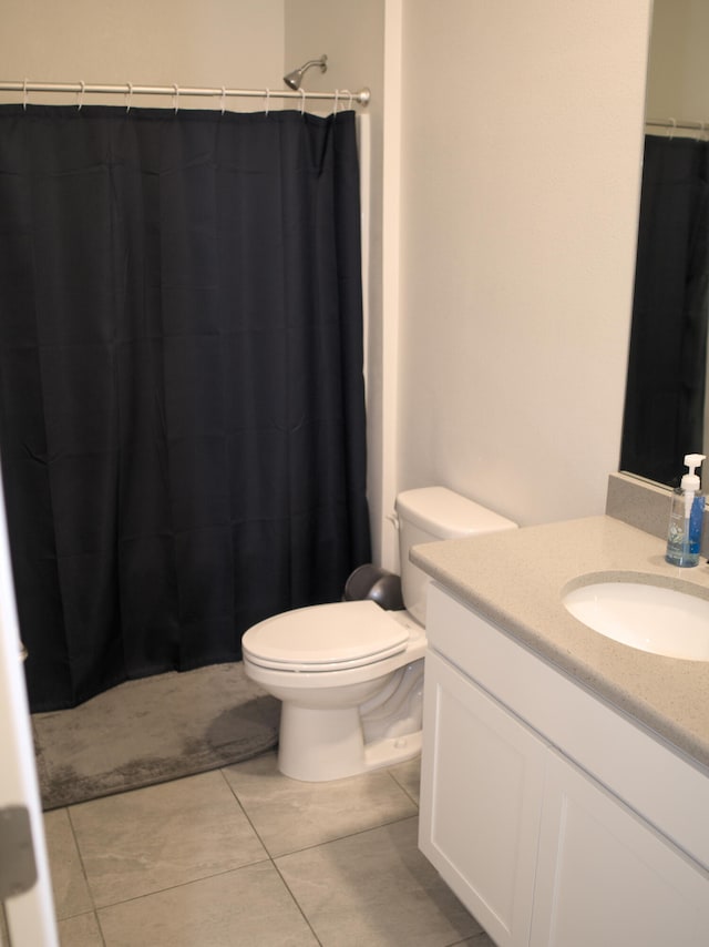 bathroom with vanity, toilet, a shower with shower curtain, and tile patterned floors