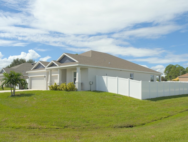 view of front of home with a front yard and a garage