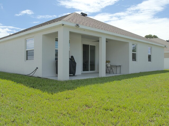 rear view of property featuring a patio and a yard