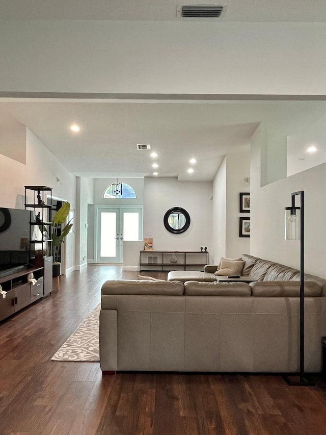 living room featuring lofted ceiling, dark wood-type flooring, and french doors