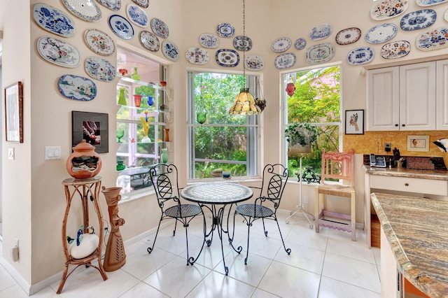 dining area with a high ceiling and light tile patterned flooring