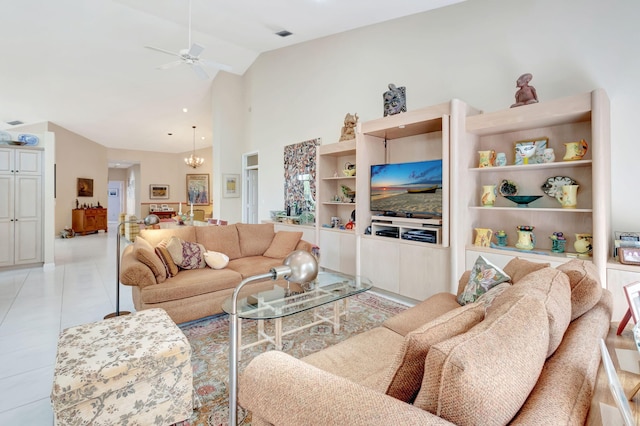 tiled living room with ceiling fan with notable chandelier and high vaulted ceiling