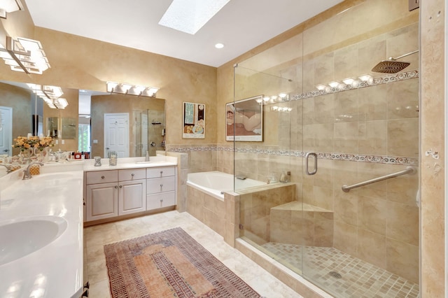 bathroom with a skylight, vanity, plus walk in shower, and tile patterned flooring