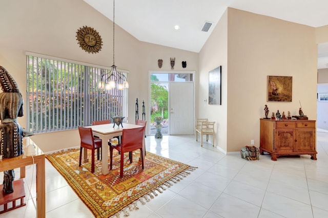 dining room featuring a notable chandelier, light tile patterned floors, and high vaulted ceiling