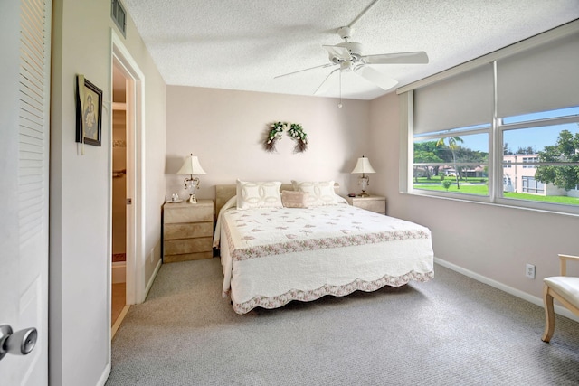 carpeted bedroom featuring ceiling fan and a textured ceiling