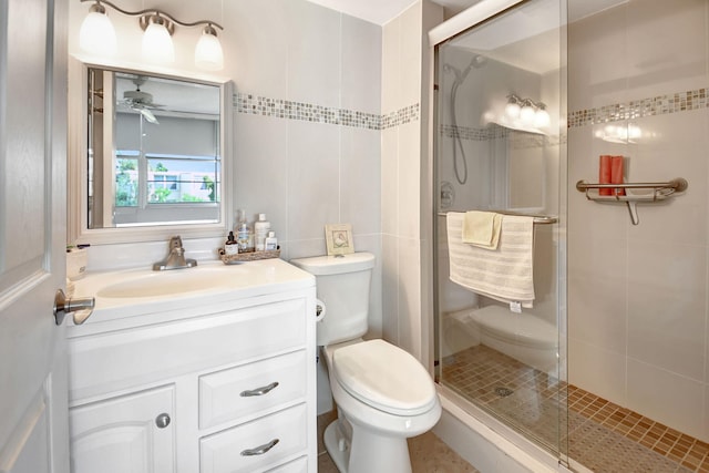 bathroom featuring vanity, toilet, ceiling fan, and a shower with door