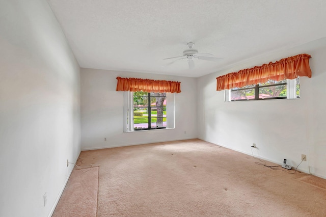 carpeted spare room featuring a textured ceiling and ceiling fan