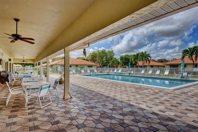 view of swimming pool featuring a grill, ceiling fan, and a patio area