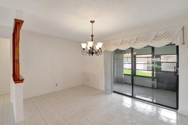 spare room with light tile patterned floors and a notable chandelier