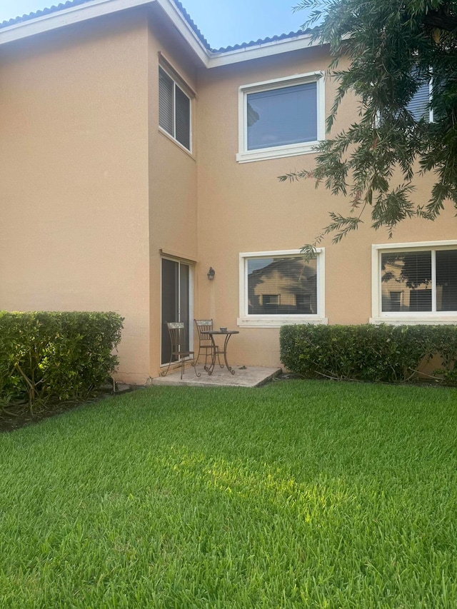 rear view of house with a yard and a patio area