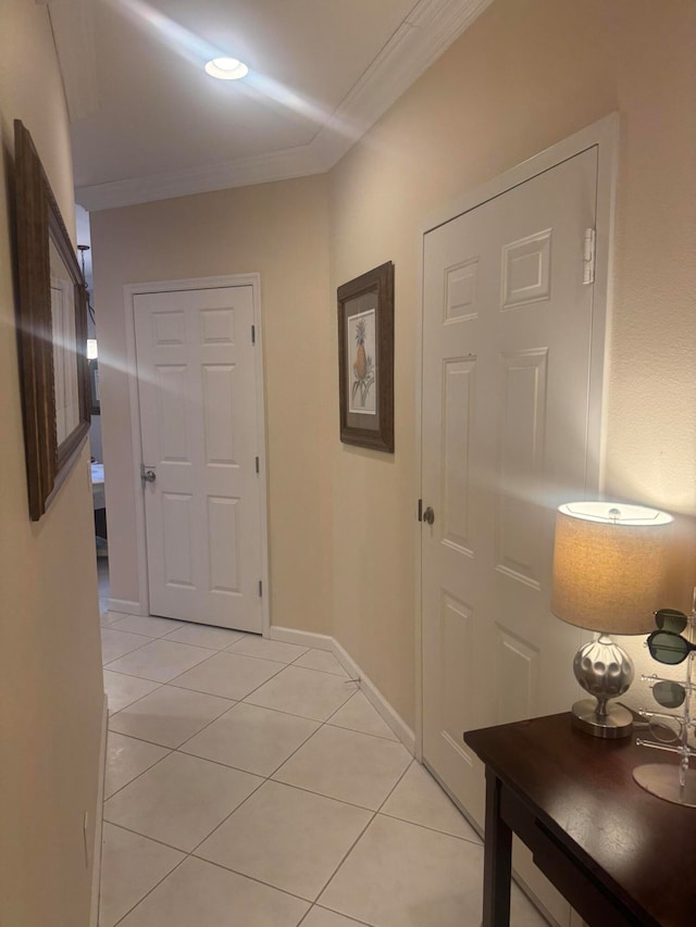 hall featuring ornamental molding and light tile patterned floors