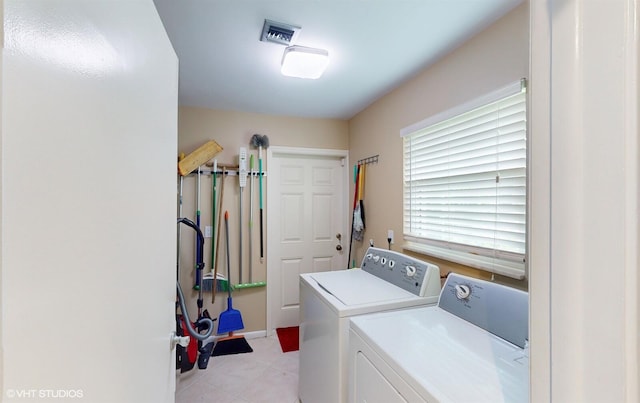 clothes washing area featuring light tile patterned floors, washing machine and dryer, laundry area, and visible vents