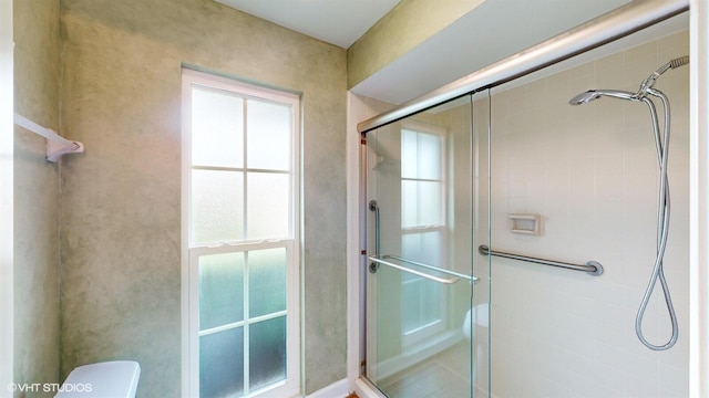 full bath featuring toilet and a stall shower