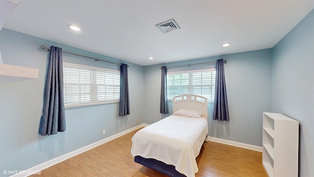 bedroom with light wood-style floors, recessed lighting, visible vents, and baseboards