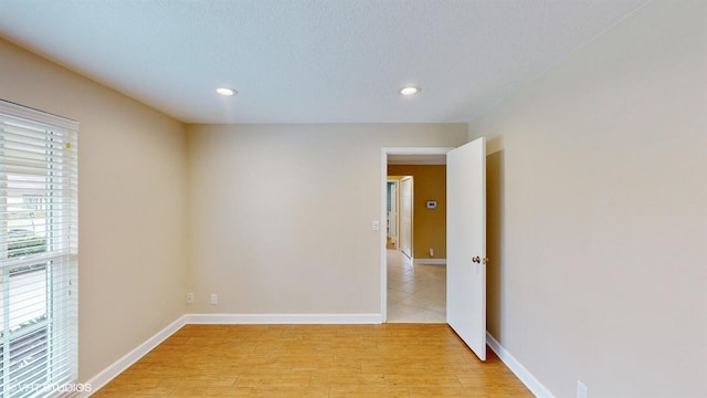 unfurnished room with light wood-style floors, baseboards, and recessed lighting