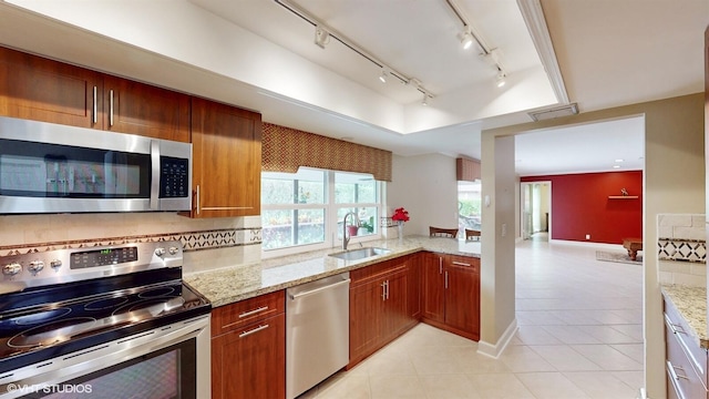 kitchen featuring rail lighting, visible vents, appliances with stainless steel finishes, light tile patterned flooring, and a sink