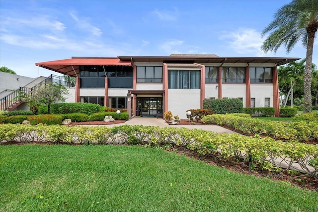 view of front of house with a front lawn, a sunroom, and a patio area