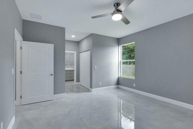 unfurnished bedroom featuring ceiling fan, ensuite bathroom, and a closet